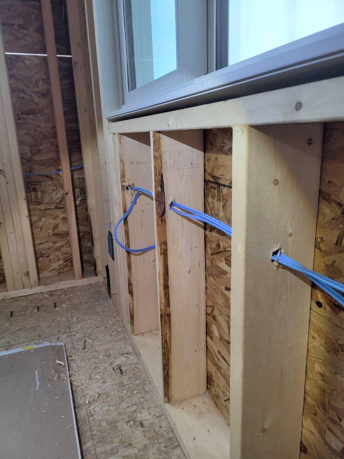 A series of studs with electrical conductors ran through being assessed during a new build home inspection. 