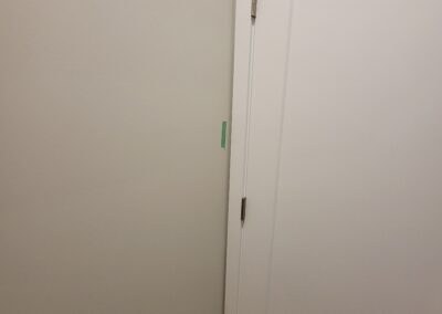 New home interior door and wall trim inspected for alignment and finishing quality, marked for builder correction.