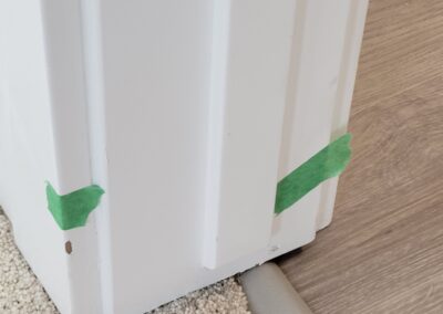 Corner base trim damage in a newly built home, with pre-delivery inspection tape marking repair needs.